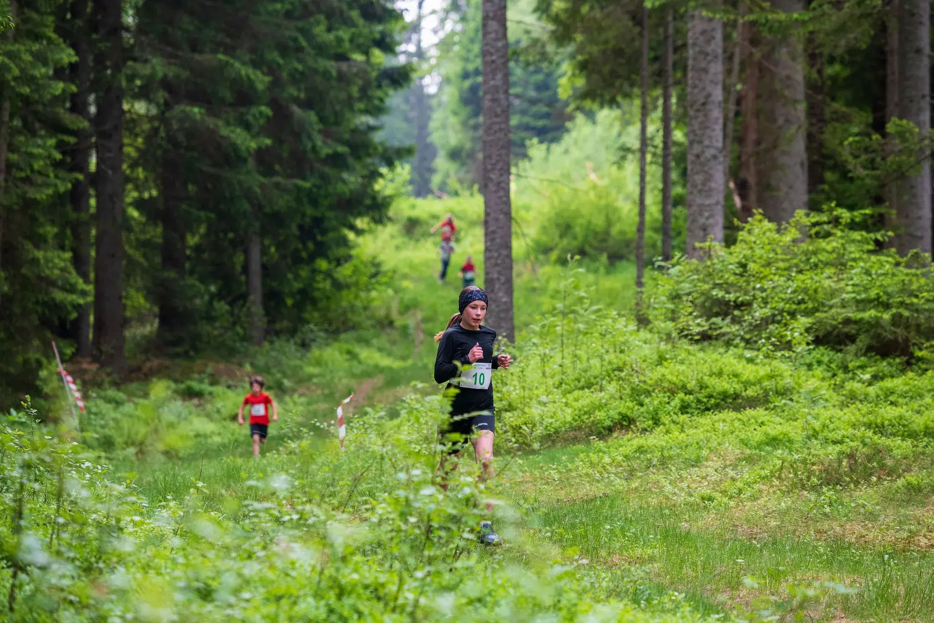 Ett barn springer ensamt över gläntan under barnloppet, 2024