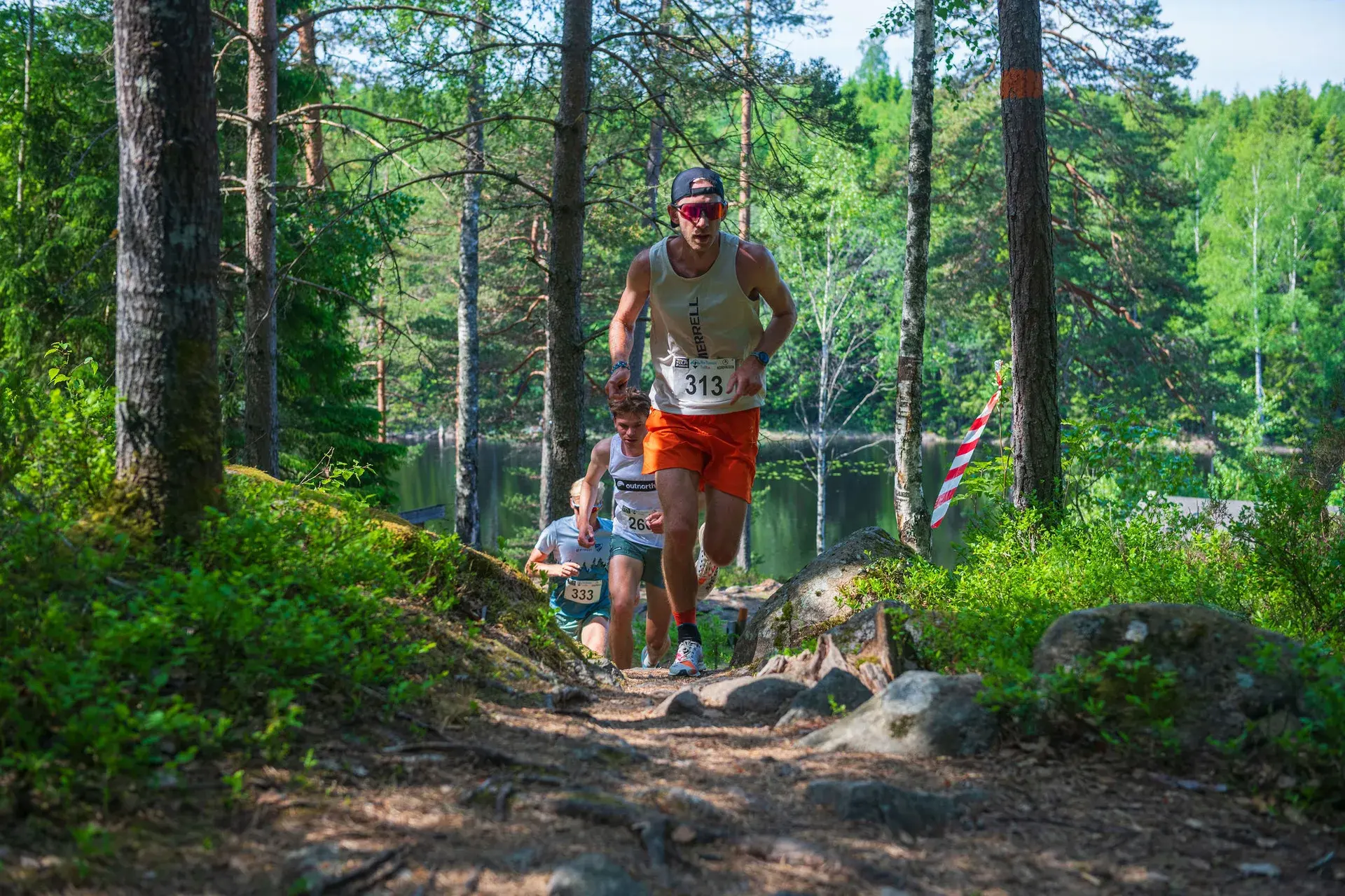 Täten på 21 km på väg uppför en stenig backe med sjön bakom sig, 2024