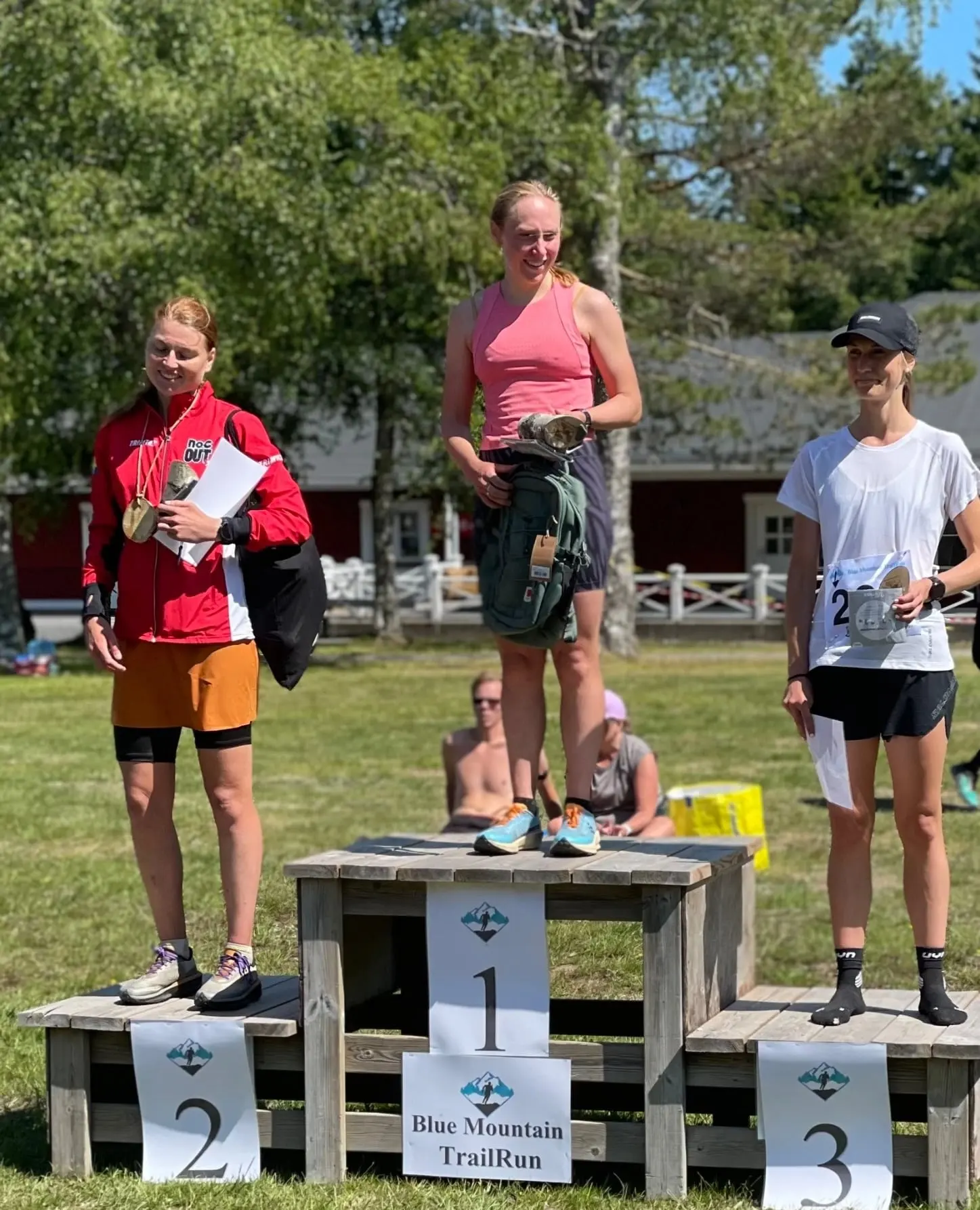 Pallen för damernas 21 km 2023: Anna Wehlin överst med trämedaljen i handen